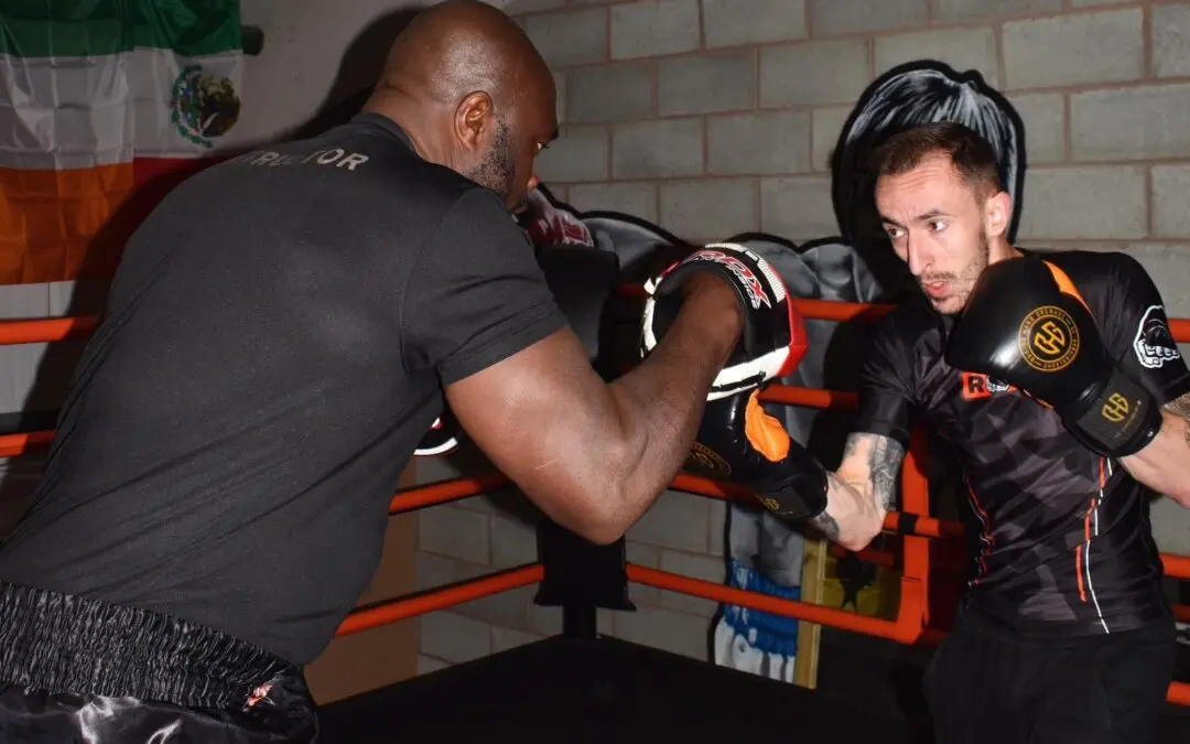Roar Martial Arts coach trains a student with focus pad work inside the boxing ring